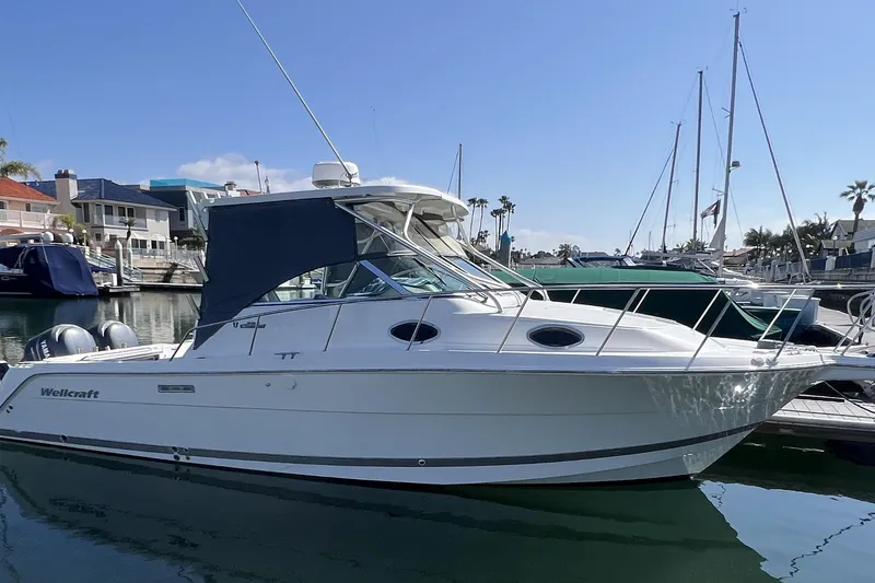 Slide: The Image of 2006 Wellcraft 290 Coastal boat docked in a marina under clear skies. - 2