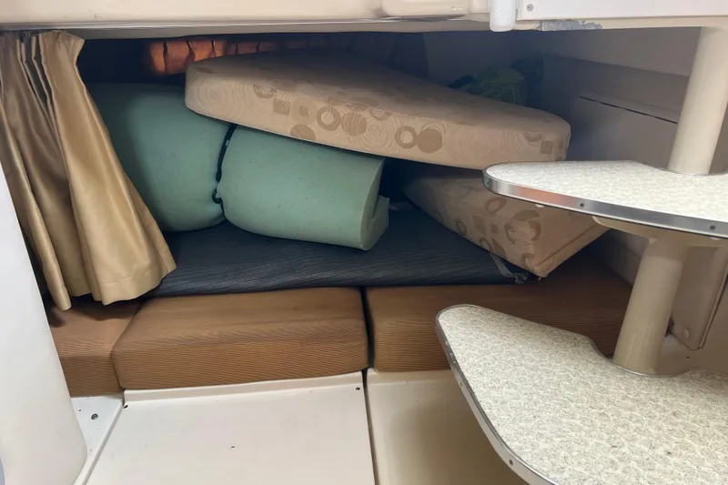 Slide: The Image of 2006 Wellcraft 290 Coastal cabin interior with stacked cushions and compact seating area. - 20