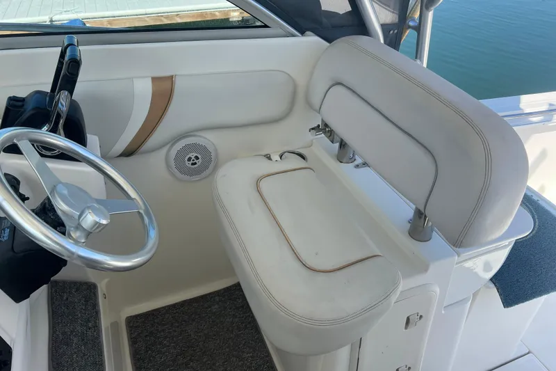 Slide: The Image of 2006 Wellcraft 290 Coastal helm with steering wheel and cushioned seat. - 21