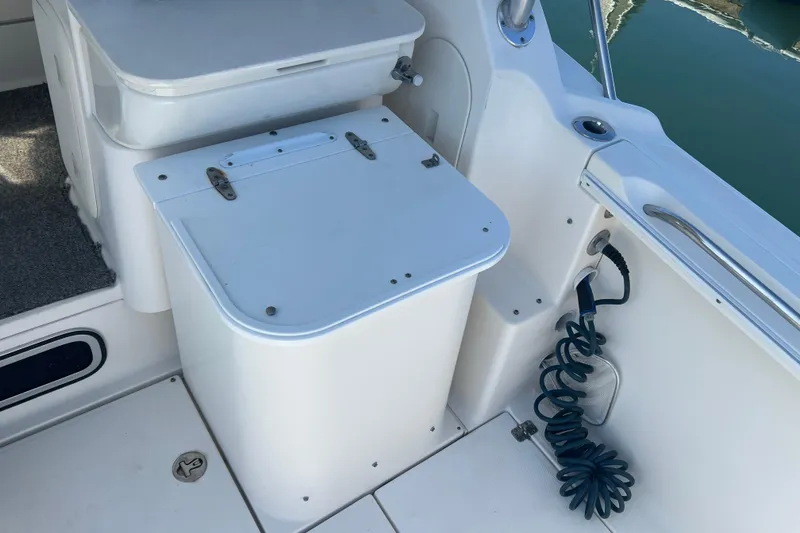 Slide: The Image of 2006 Wellcraft 290 Coastal boat interior with storage compartment and coiled hose. - 23