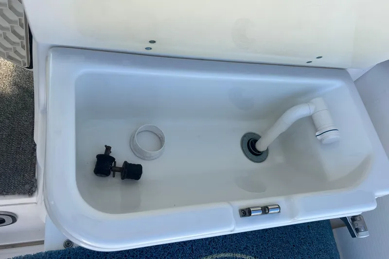 Slide: The Image of Livewell compartment in 2006 Wellcraft 290 Coastal boat, featuring drain and fittings. - 30