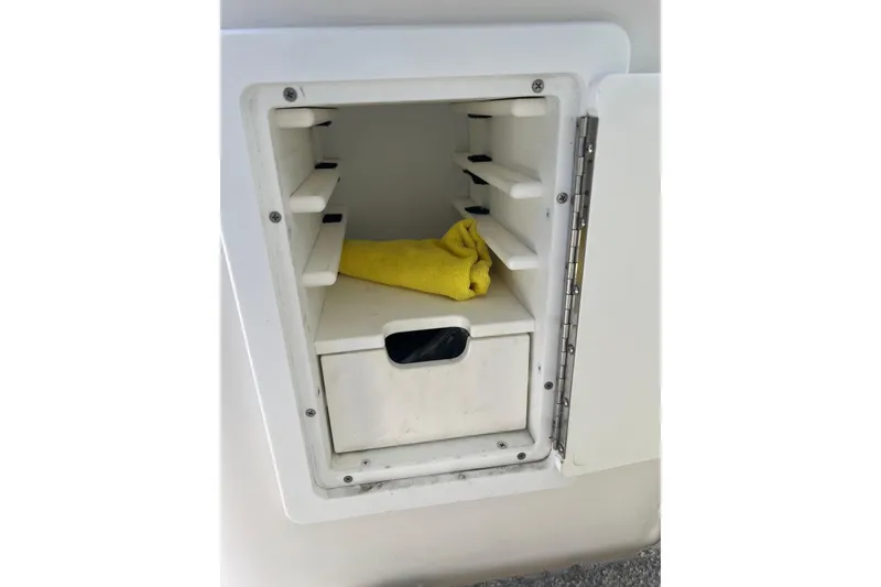Slide: The Image of Storage compartment on a 2006 Wellcraft 290 Coastal boat with a yellow cloth inside. - 31