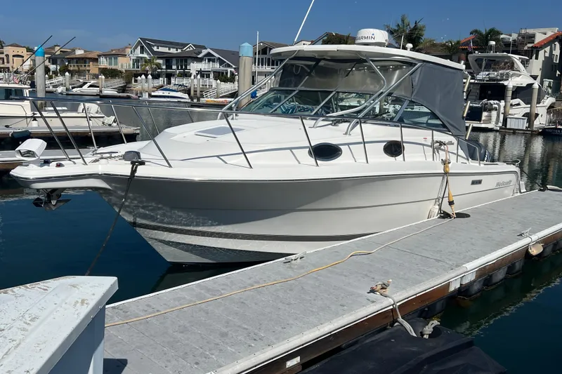 Slide: The Image of 2006 Wellcraft 290 Coastal boat docked at marina, surrounded by other vessels. - 39