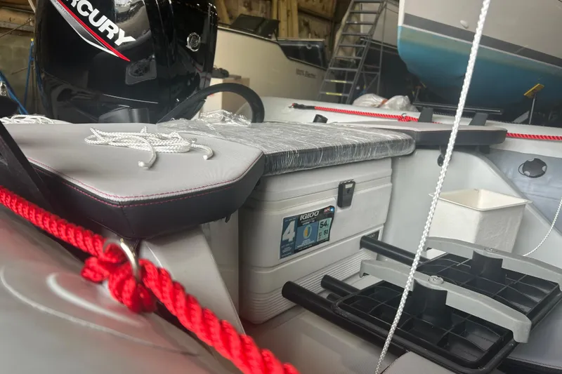 Slide: The Image of 2025 Zodiac Open 6.5 boat interior with Mercury engine and Igloo cooler. - 10