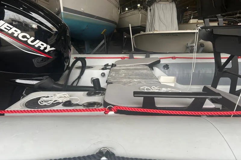 Slide: The Image of 2025 Zodiac Open 6.5 boat with Mercury engine, docked indoors. - 12
