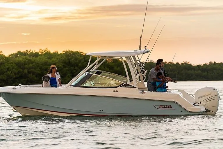 Slide: The Image of 2026 Boston Whaler 240 Vantage boat cruising at sunset with passengers and fishing gear. - 12