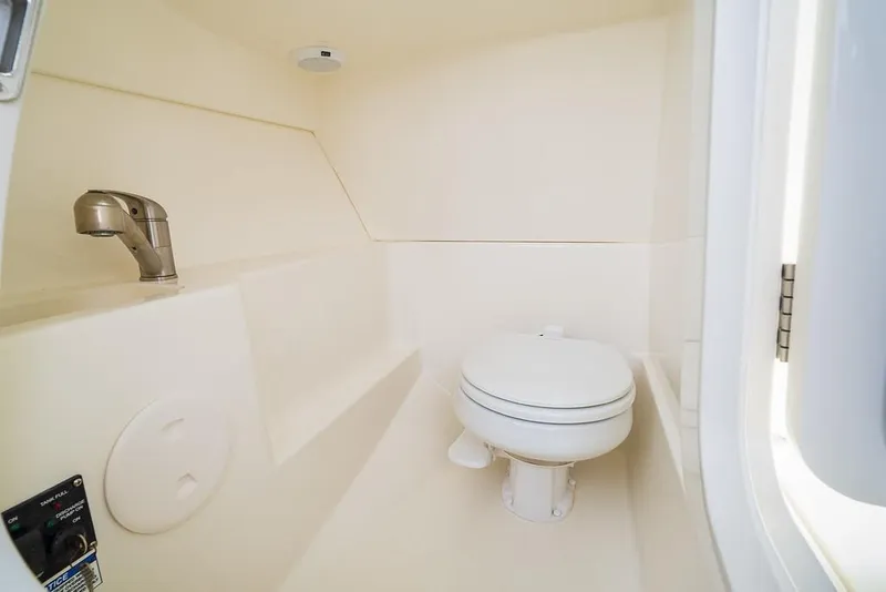 Slide: The Image of Interior of 2026 Boston Whaler 240 Vantage boat bathroom with toilet and sink. - 14