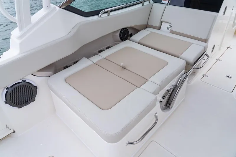 Slide: The Image of 2026 Boston Whaler 240 Vantage boat interior with beige seating and speaker. - 9