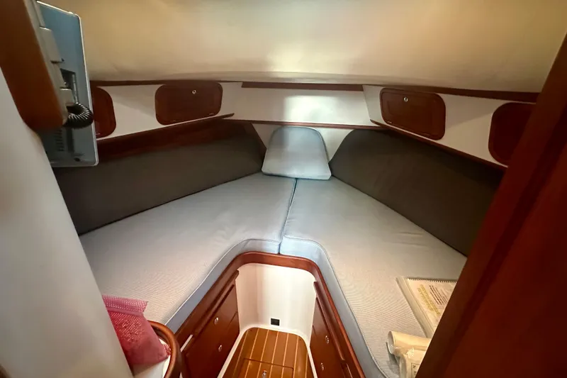 Slide: The Image of 2005 Legacy Yachts 34 Express cabin interior with cozy V-berth and wooden accents. - 10