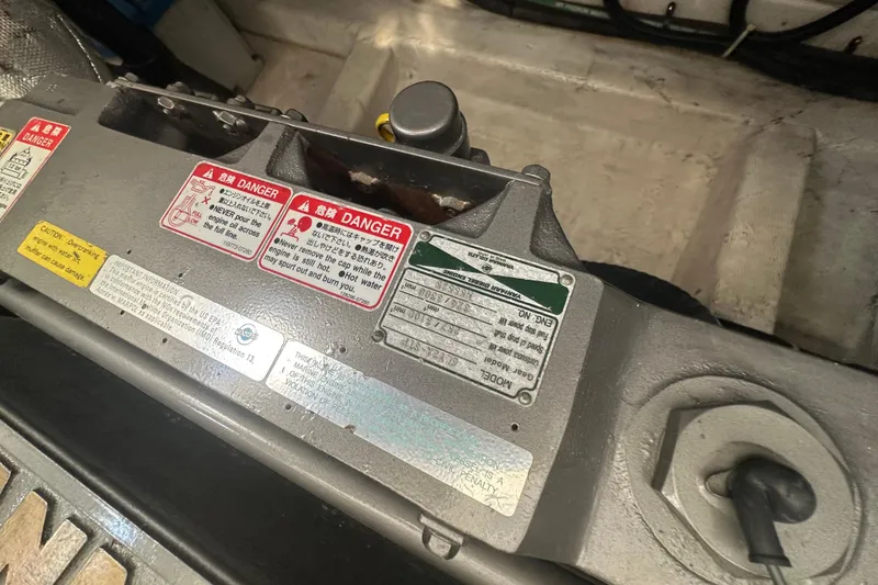 Slide: The Image of Engine compartment of 2005 Legacy Yachts 34 Express with safety warning labels. - 16