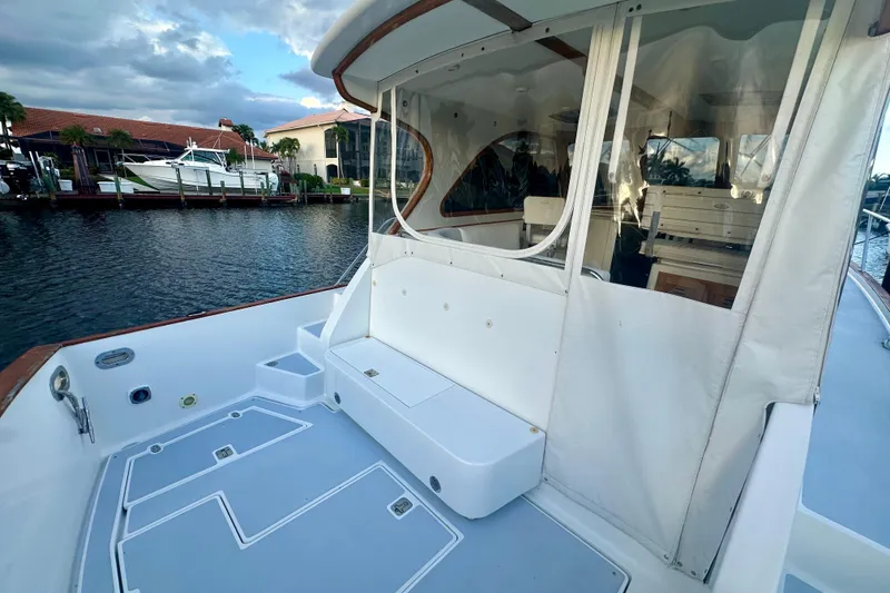 Slide: The Image of 2005 Legacy Yachts 34 Express boat deck with seating, docked by waterfront homes. - 3