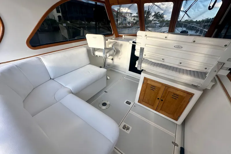 Slide: The Image of 2005 Legacy Yachts 34 Express interior with white seating and wooden accents. - 4