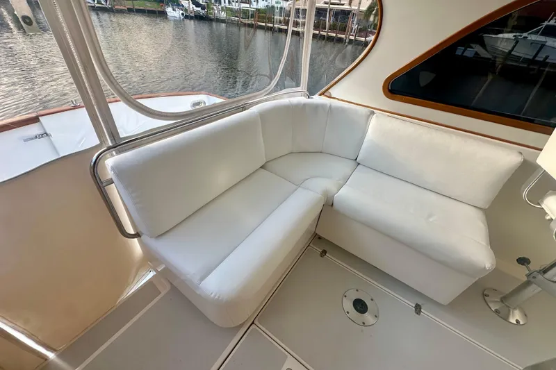Slide: The Image of White cushioned seating area on 2005 Legacy Yachts 34 Express, overlooking marina. - 5