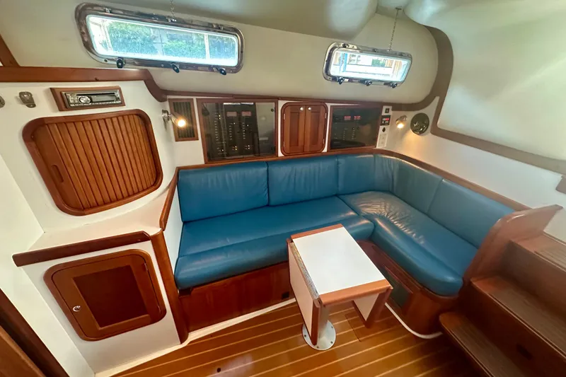 Slide: The Image of Interior of 2005 Legacy Yachts 34 Express with blue seating and wooden accents. - 8