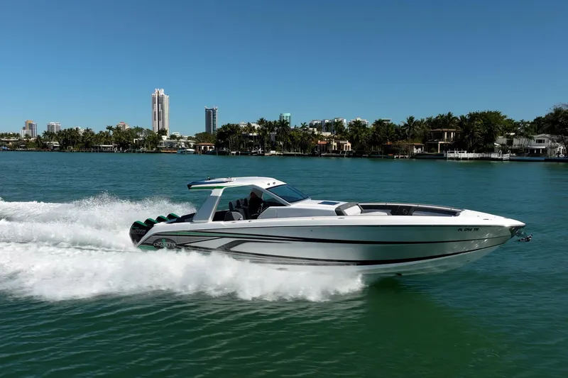 Slide: The Image of 2024 Cigarette 42' Auroris speedboat cruising on a sunny day near a coastal cityscape. - 19