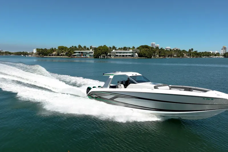 Slide: The Image of 2024 Cigarette 42' Auroris speedboat cruising on a sunny day in a scenic waterway. - 3