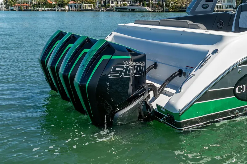 Slide: The Image of 2024 Cigarette 42' Auroris with quad outboard engines on a serene water backdrop. - 31