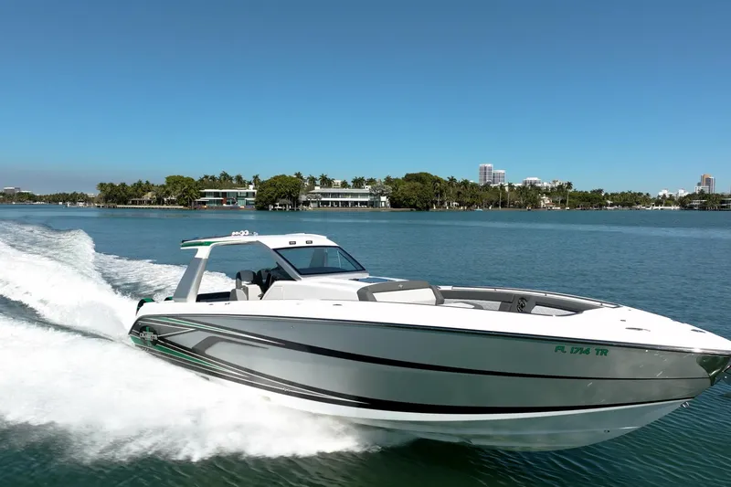 Slide: The Image of 2024 Cigarette 42' Auroris speedboat cruising on a sunny day in a scenic waterway. - 4