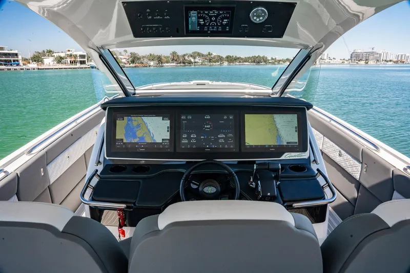 Slide: The Image of 2024 Cigarette 42' Auroris boat cockpit with advanced navigation displays on a serene water backdrop. - 71