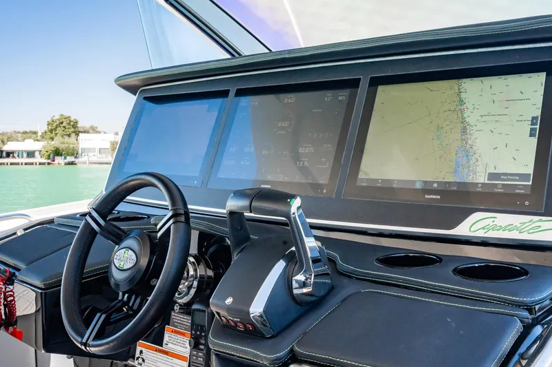 Slide: The Image of 2024 Cigarette 42' Auroris boat dashboard with advanced navigation screens and steering wheel. - 8
