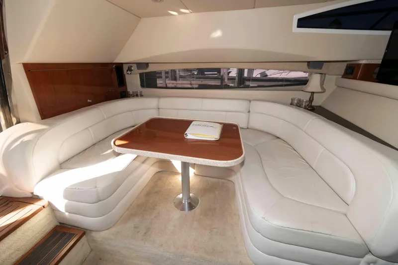 Slide: The Image of Luxurious interior of 2005 Regal Commodore 3880 yacht with white leather seating and wooden table. - 10