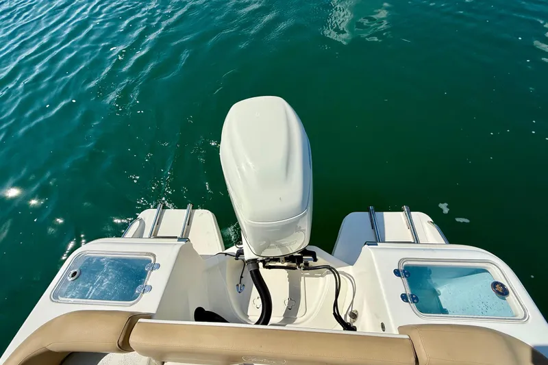 Slide: The Image of 2021 Pioneer 222 Islander boat engine and deck on calm water. - 13