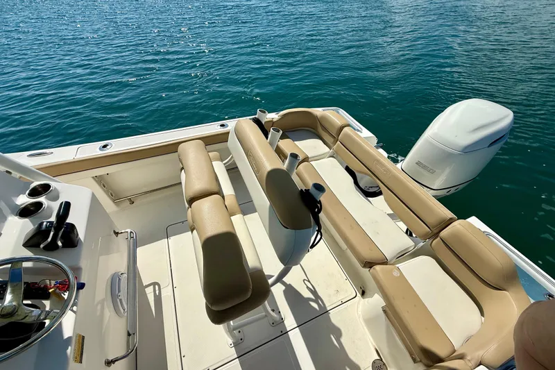 Slide: The Image of 2021 Pioneer 222 Islander boat interior with tan seating and outboard motor on blue water. - 16