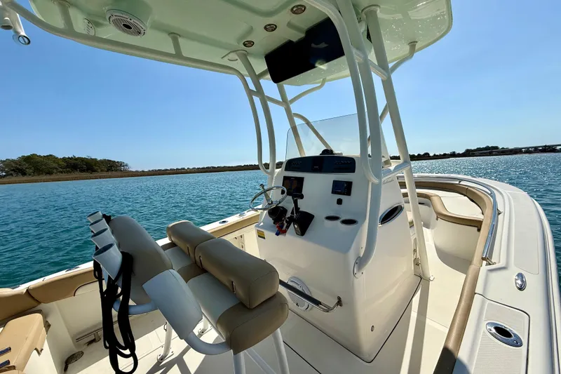 Slide: The Image of 2021 Pioneer 222 Islander boat interior with helm, seats, and ocean view. - 19
