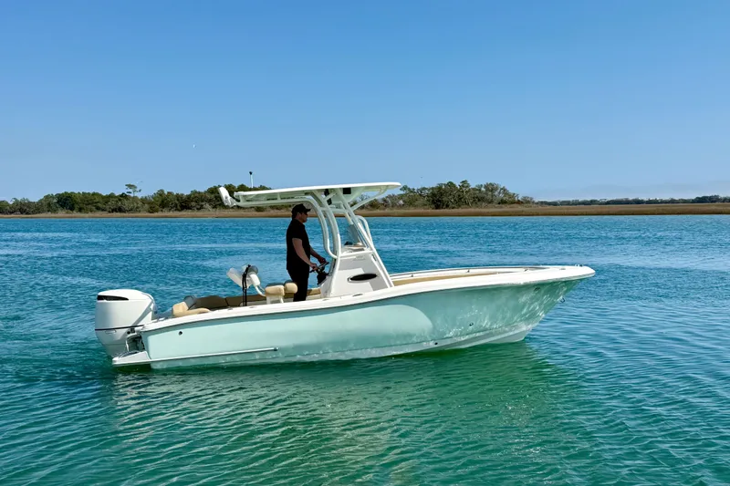 Slide: The Image of 2021 Pioneer 222 Islander boat cruising on clear blue water. - 2