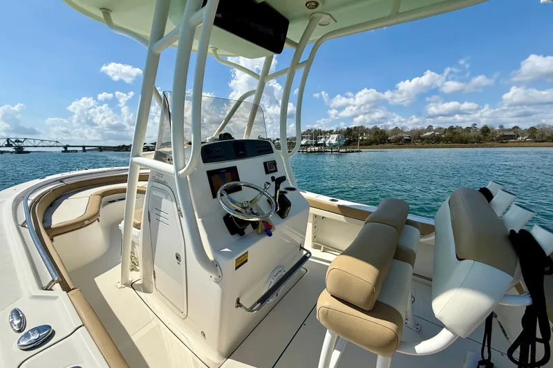 Slide: The Image of 2021 Pioneer 222 Islander boat interior with helm, seats, and scenic water view. - 20