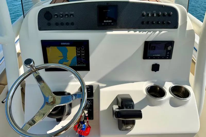 Slide: The Image of 2021 Pioneer 222 Islander boat dashboard with steering wheel, navigation screens, and controls. - 23