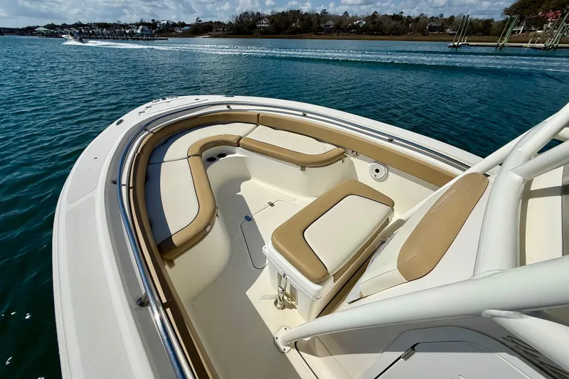 Slide: The Image of 2021 Pioneer 222 Islander boat with tan seating, cruising on a sunny day. - 27