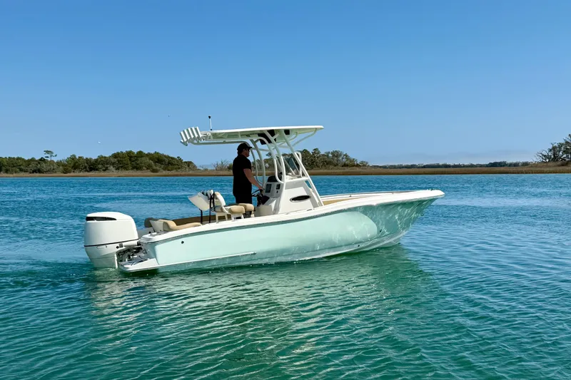 Slide: The Image of 2021 Pioneer 222 Islander boat cruising on clear blue water under a sunny sky. - 3