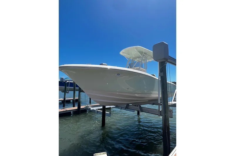 Slide: The Image of 2021 Pioneer 222 Islander boat on lift under clear blue sky. - 31