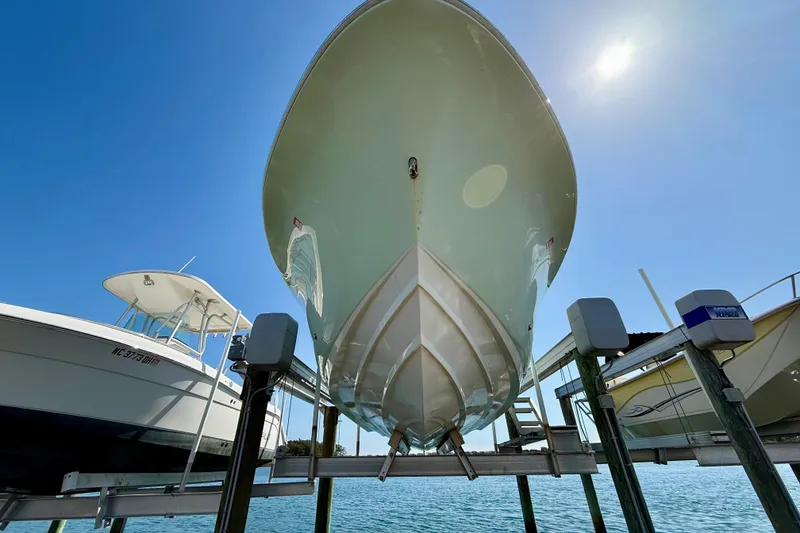Slide: The Image of 2021 Pioneer 222 Islander boat on lift under clear blue sky. - 32