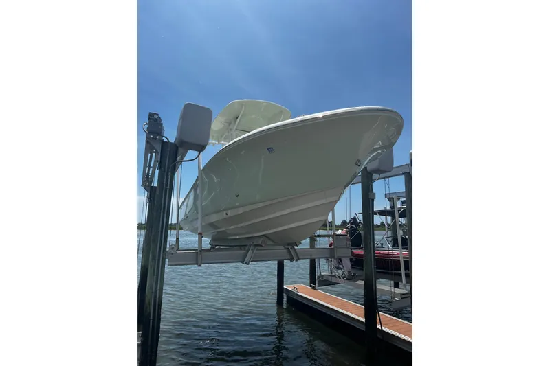 Slide: The Image of 2021 Pioneer 222 Islander boat on lift under clear blue sky. - 33