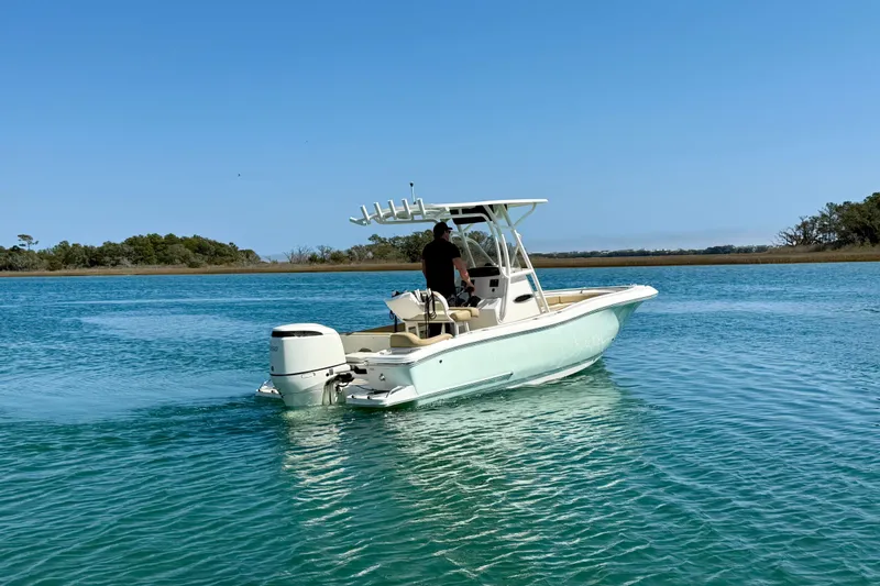 Slide: The Image of 2021 Pioneer 222 Islander boat cruising on clear blue water under a sunny sky. - 4