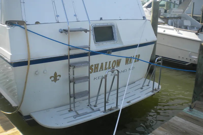 Slide: The Image of 1987 Hatteras 40 Motor Yacht docked, rear view with ladder and ropes. - 11