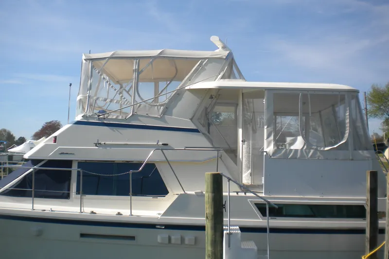 Slide: The Image of 1987 Hatteras 40 Motor Yacht docked, featuring white exterior and enclosed upper deck. - 13