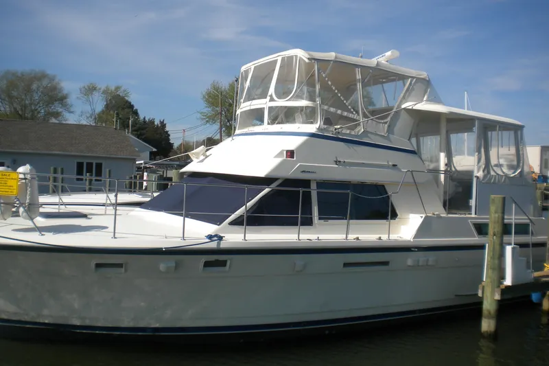 Slide: The Image of 1987 Hatteras 40 Motor Yacht docked, featuring a spacious deck and enclosed flybridge. - 14