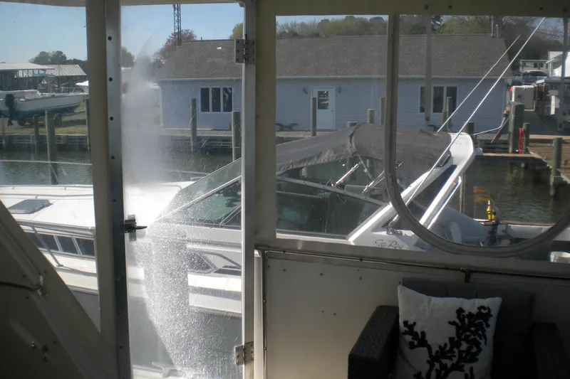 Slide: The Image of 1987 Hatteras 40 Motor Yacht docked, viewed from interior with marina background. - 18