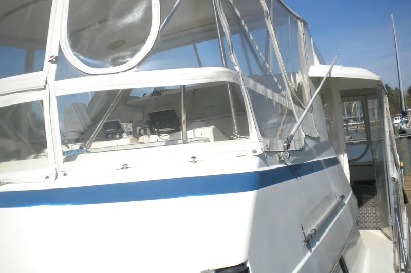 Slide: The Image of 1987 Hatteras 40 Motor Yacht with enclosed cockpit, docked under clear blue sky. - 22