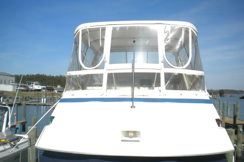 Slide: The Image of 1987 Hatteras 40 Motor Yacht docked at a marina under clear blue skies. - 23