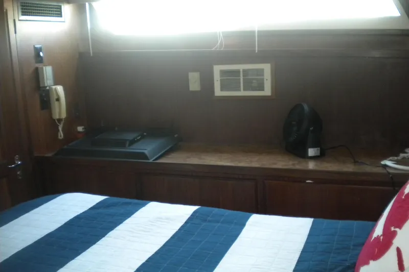 Slide: The Image of Interior cabin of 1987 Hatteras 40 Motor Yacht with striped bedding and wooden paneling. - 26
