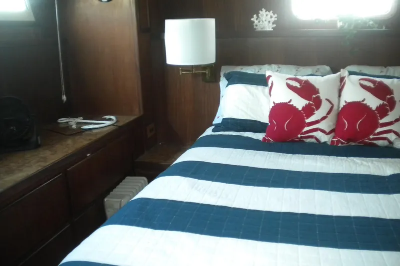 Slide: The Image of Cozy bedroom in 1987 Hatteras 40 Motor Yacht with nautical decor and crab-themed pillows. - 27