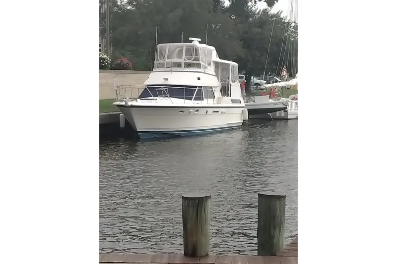 Slide: The Image of 1987 Hatteras 40 Motor Yacht docked in a serene marina setting. - 3