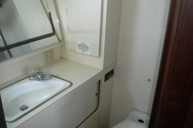 Slide: The Image of 1987 Hatteras 40 Motor Yacht bathroom with sink, mirror, and toilet. - 30
