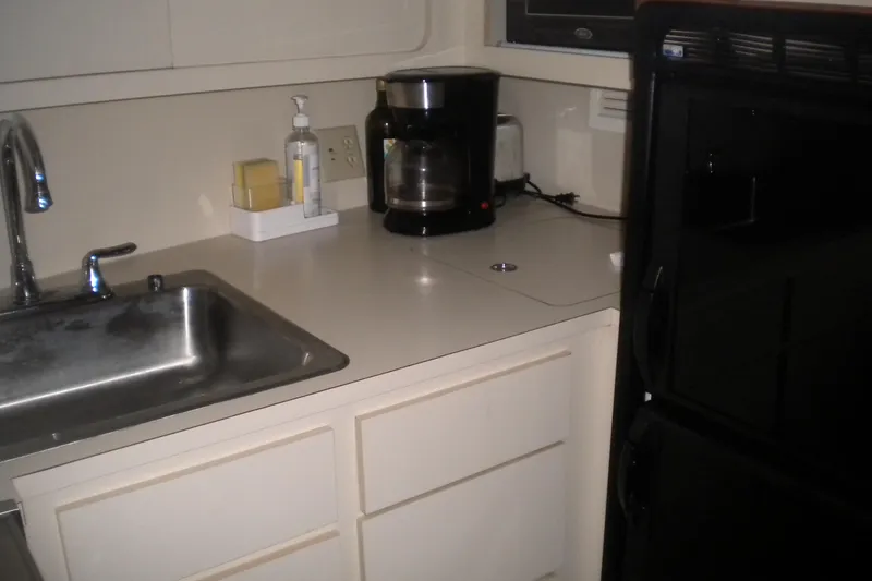 Slide: The Image of Compact kitchen area in a 1987 Hatteras 40 Motor Yacht with sink and coffee maker. - 33
