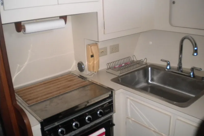 Slide: The Image of Compact kitchen area in a 1987 Hatteras 40 Motor Yacht with stove and sink. - 36