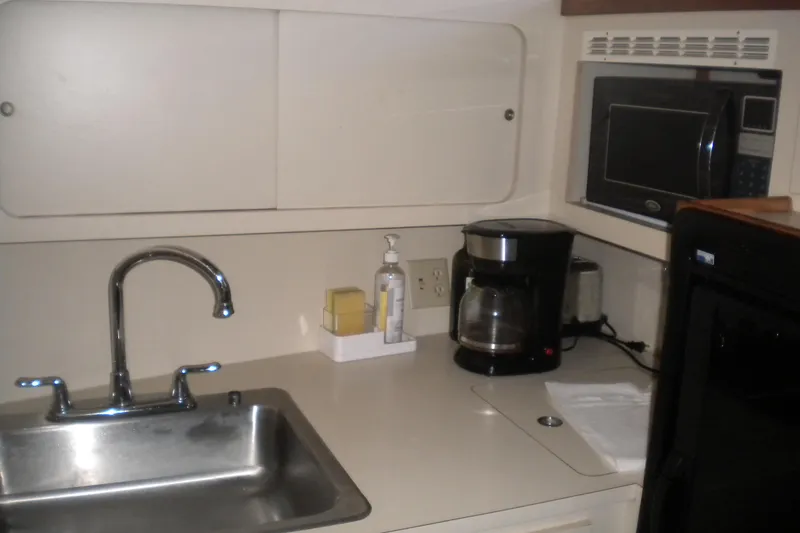 Slide: The Image of Compact kitchen area in a 1987 Hatteras 40 Motor Yacht with sink and appliances. - 37